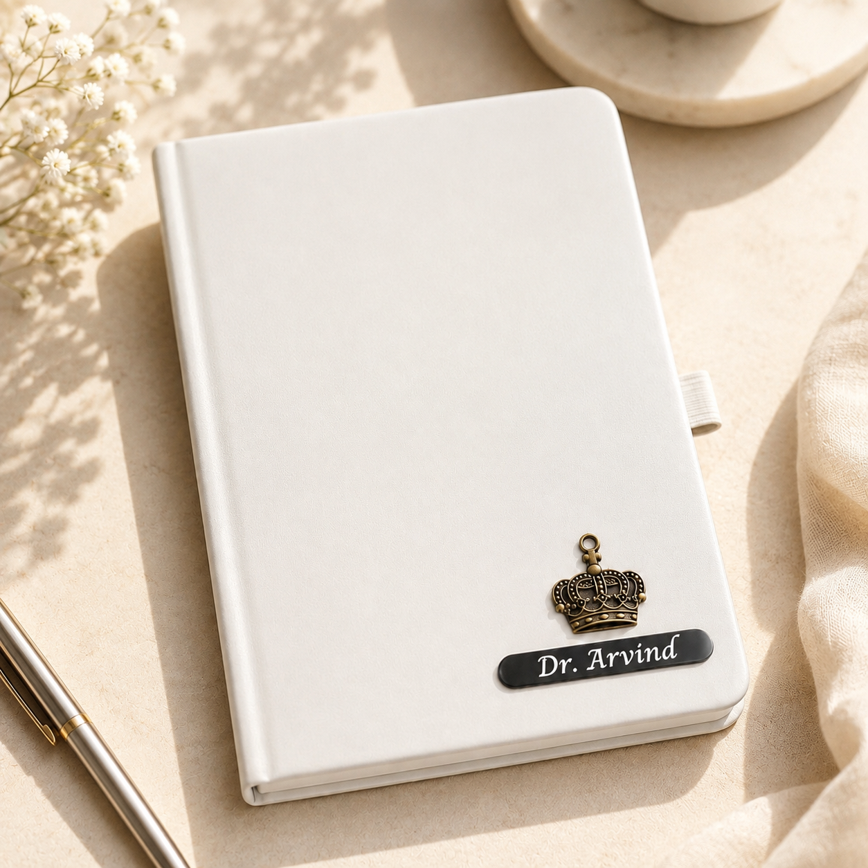 Personalized A5 diary with custom name and decorative charm, available in white, black, blue and red color options.